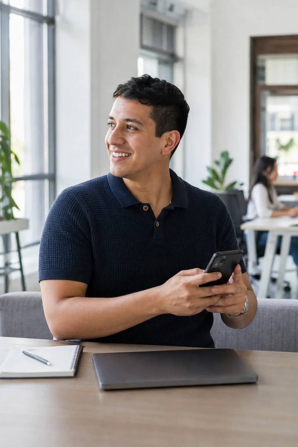 A developer at a bright workspace checking a number on his phone