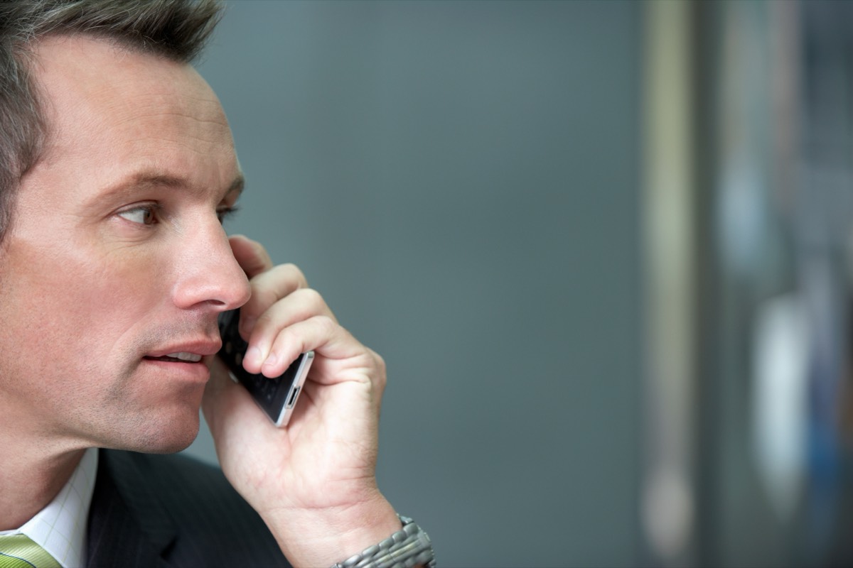 A man on the phone, unsure whether to trust an unknown caller