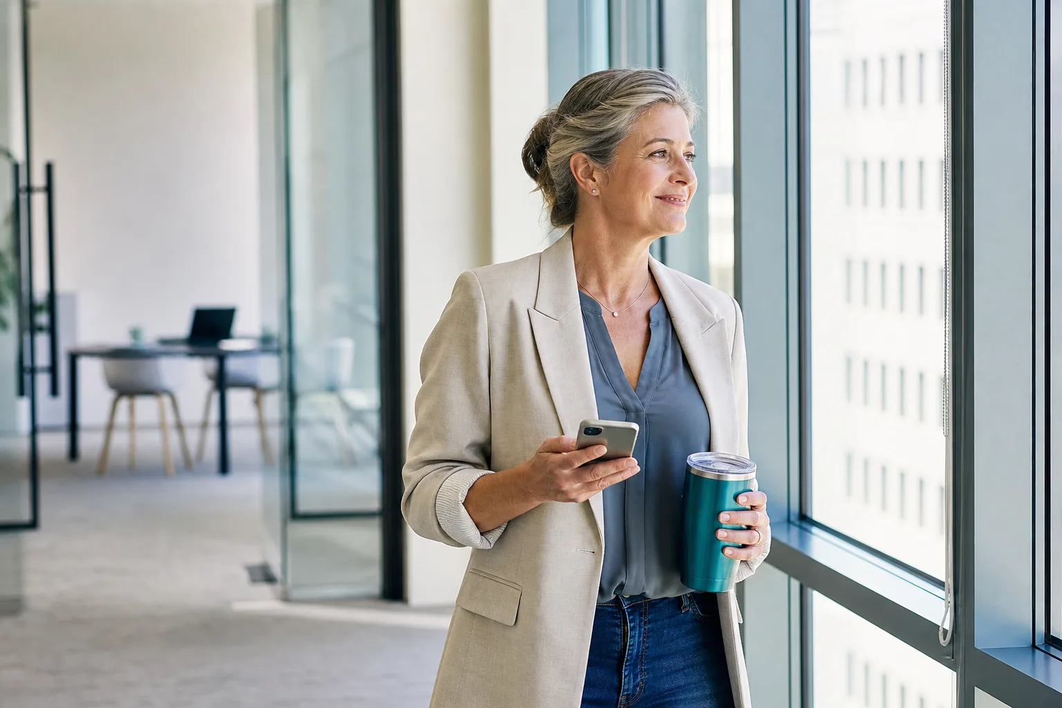 A settled operations lead at the tall windows of a bright office — know before you dial